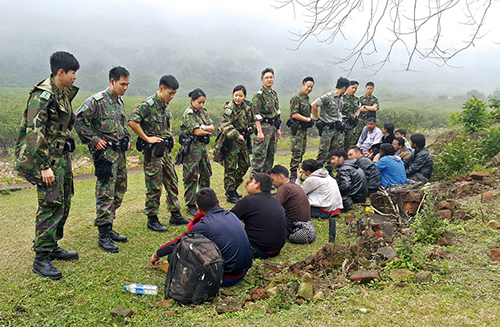 Illegal immigrants after their arrest in a country park by officers of the Quick Reaction Force New Territories North.